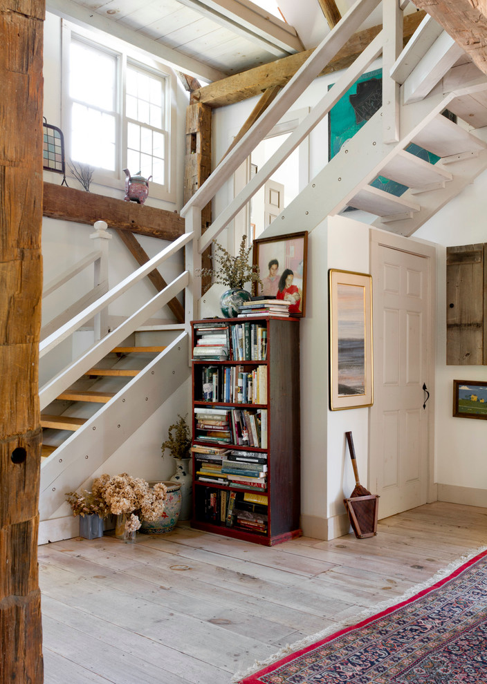 На фото: угловая лестница в стиле фьюжн с деревянными ступенями без подступенок