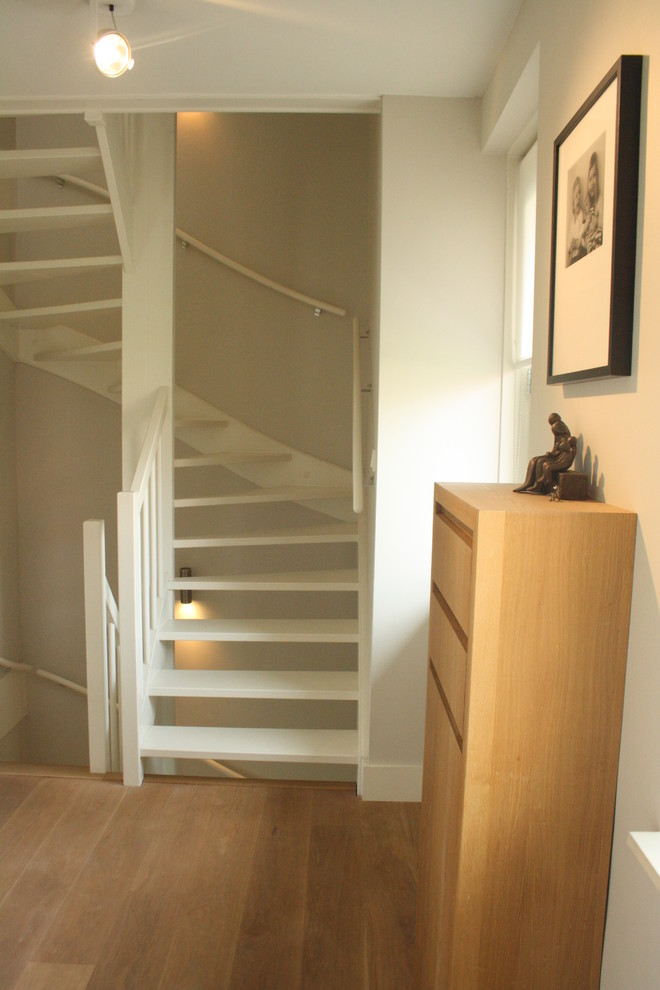 Modern inredning av en svängd trappa, med öppna sättsteg