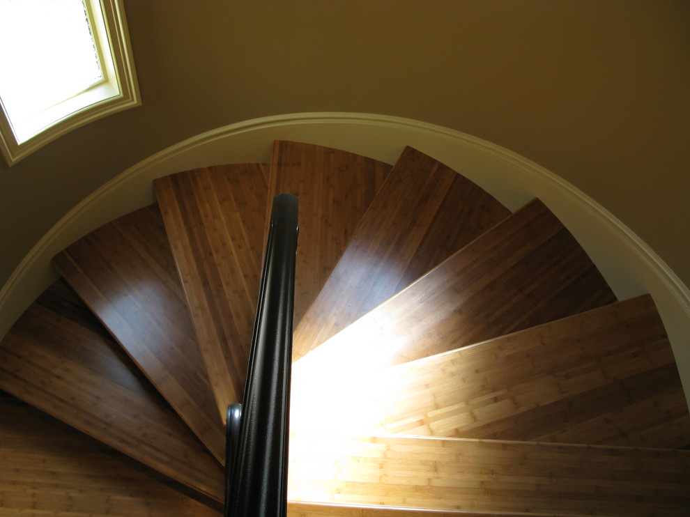 Foto de escalera de caracol actual con escalones de madera y contrahuellas de madera