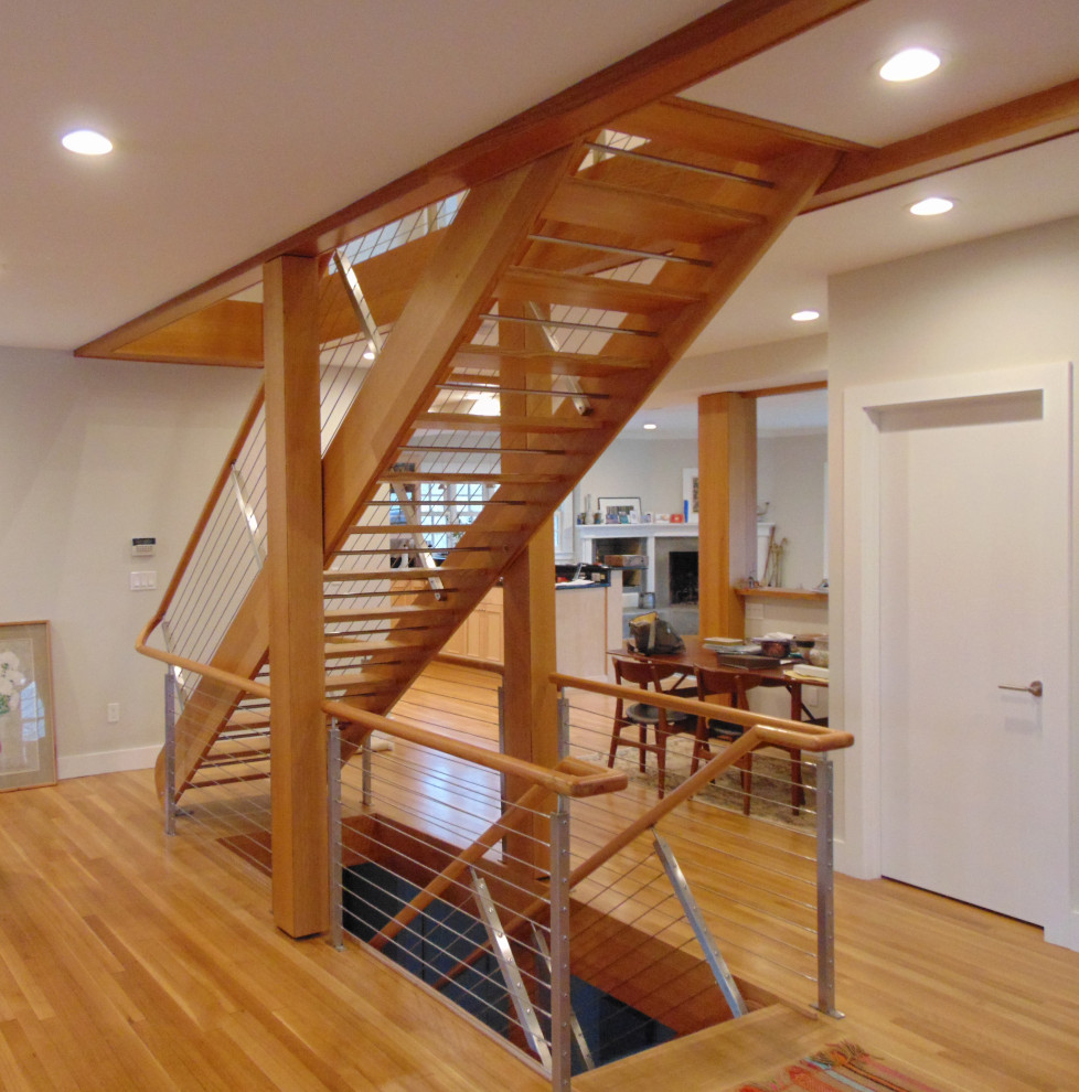На фото: большая прямая лестница в морском стиле с деревянными ступенями и перилами из тросов без подступенок с