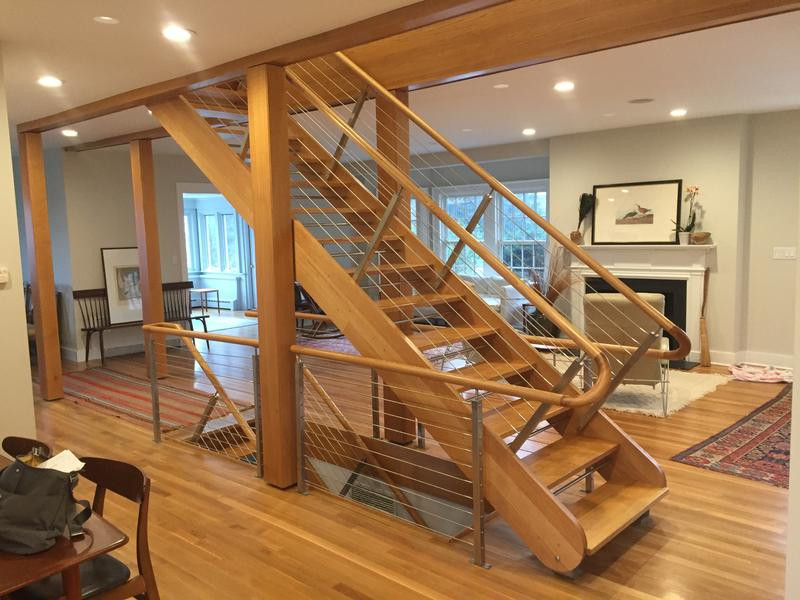 Imagen de escalera recta marinera grande sin contrahuella con escalones de madera y barandilla de cable