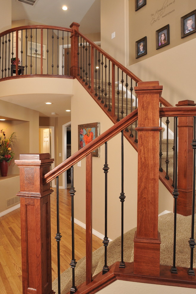 This is an example of a medium sized traditional concrete curved staircase in Denver with carpeted risers.