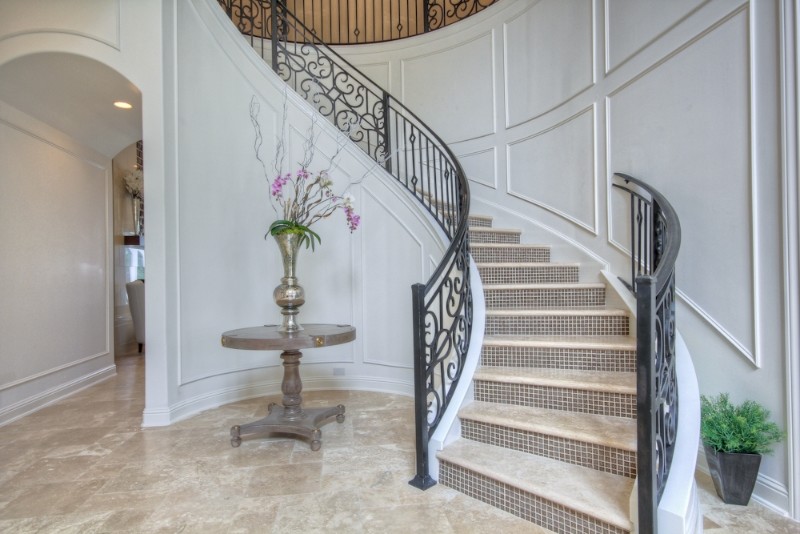 Cette image montre un grand escalier courbe traditionnel en béton avec des contremarches carrelées.