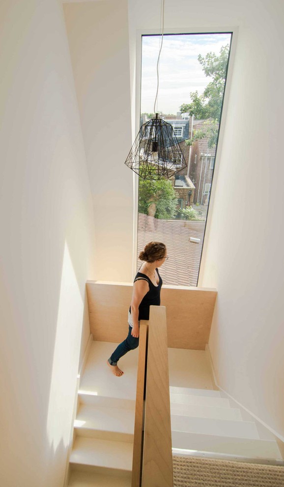 На фото: п-образная деревянная лестница среднего размера в стиле модернизм с деревянными ступенями с