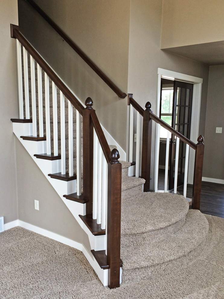 Cette photo montre un escalier courbe craftsman de taille moyenne avec des marches en moquette et des contremarches en moquette.