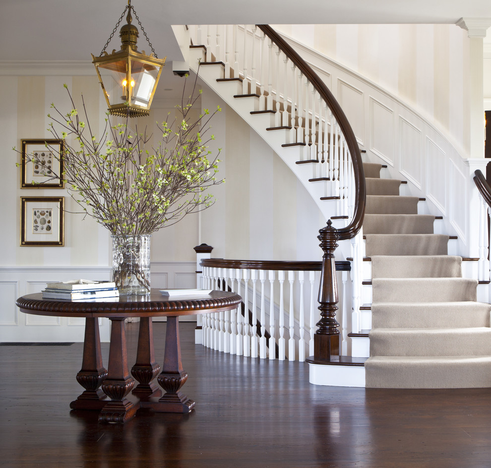 Свежая идея для дизайна: большая изогнутая лестница в классическом стиле с деревянными ступенями и крашенными деревянными подступенками - отличное фото интерьера