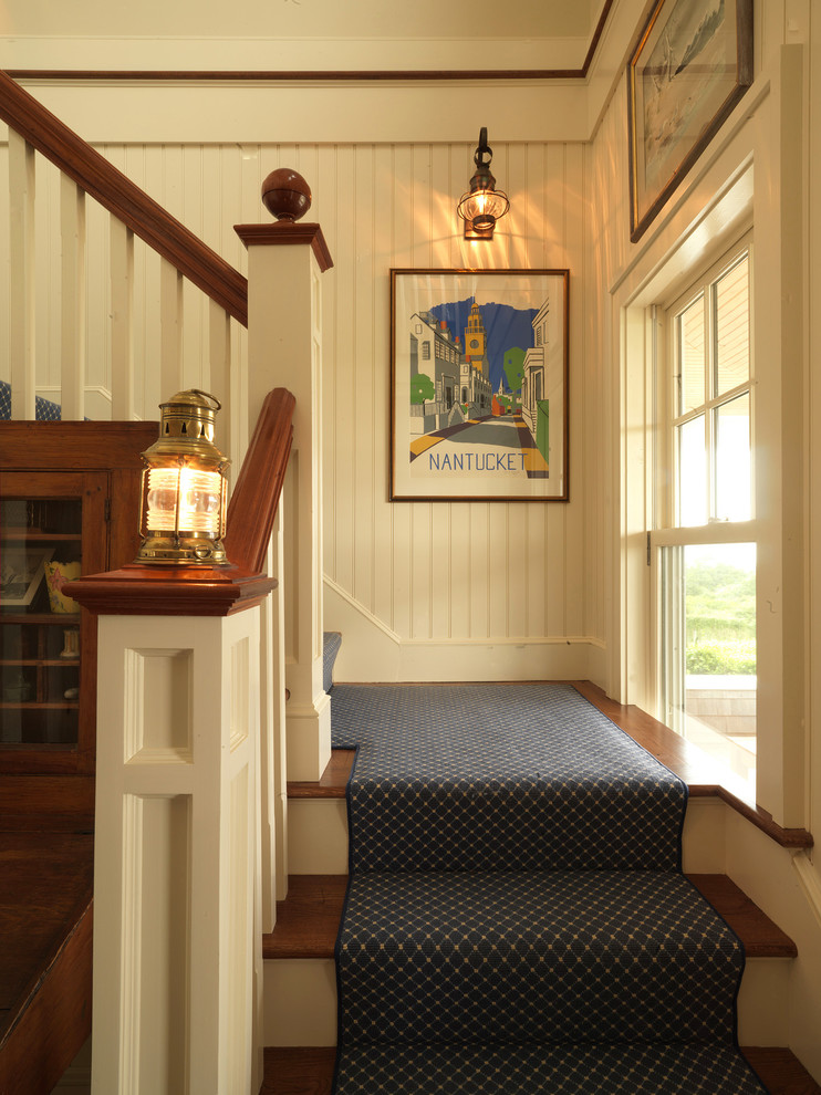 Imagen de escalera en L clásica de tamaño medio con escalones enmoquetados, contrahuellas de madera, barandilla de madera y boiserie