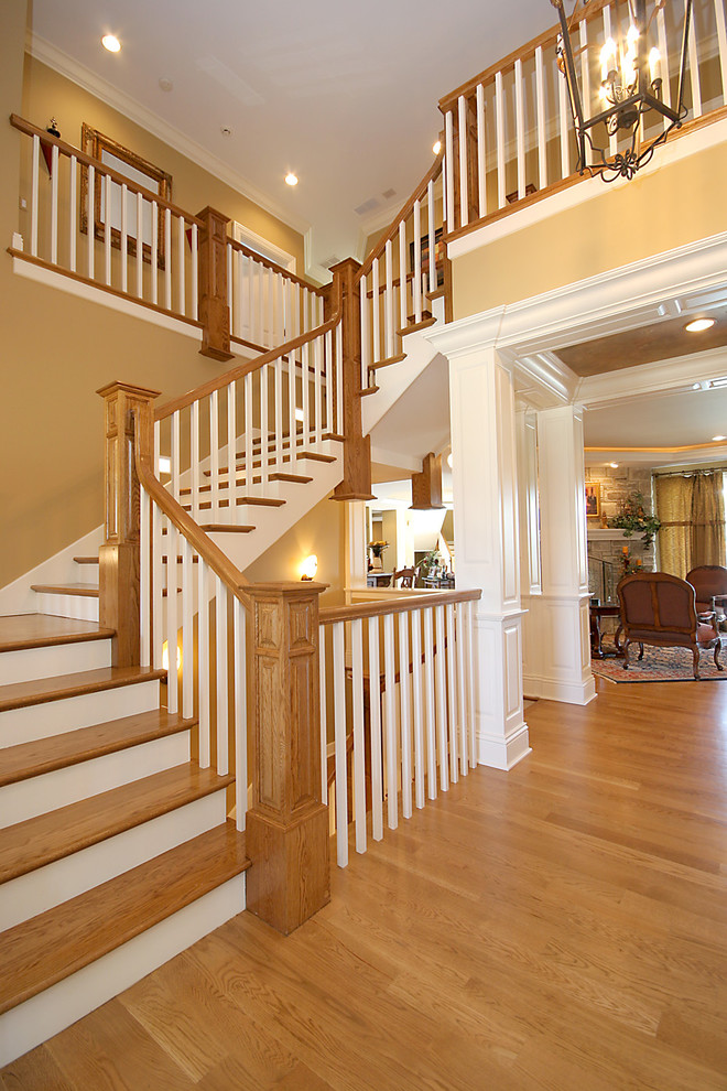 Ejemplo de escalera en L clásica grande con escalones de madera y contrahuellas de madera pintada