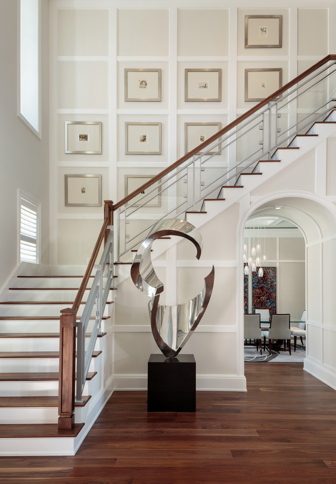 Idée de décoration pour un grand escalier peint tradition en L avec un garde-corps en matériaux mixtes et des marches en bois.