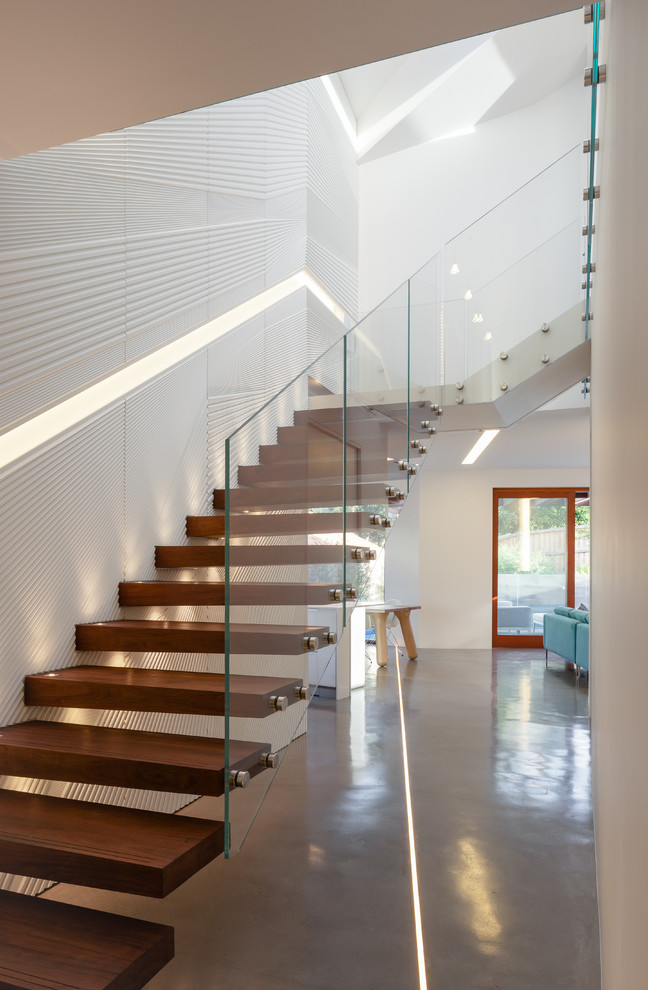 Пример оригинального дизайна: большая угловая лестница в современном стиле с деревянными ступенями без подступенок