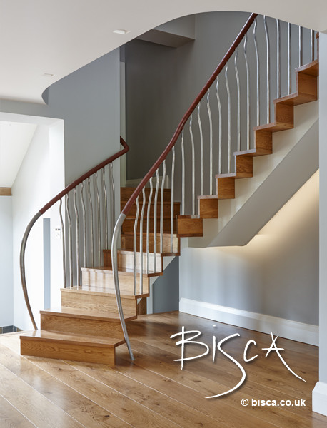 Foto de escalera curva minimalista de tamaño medio con escalones de madera y contrahuellas de madera