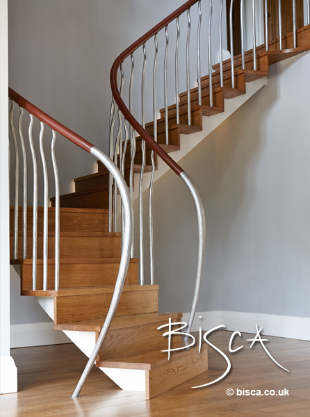 Inspiration for a mid-sized modern wooden curved staircase remodel in London with wooden risers