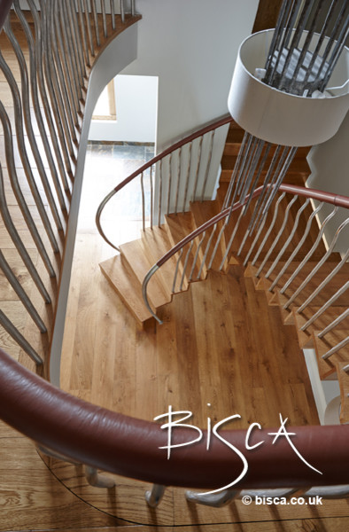 Staircase - mid-sized modern wooden curved staircase idea in London with wooden risers