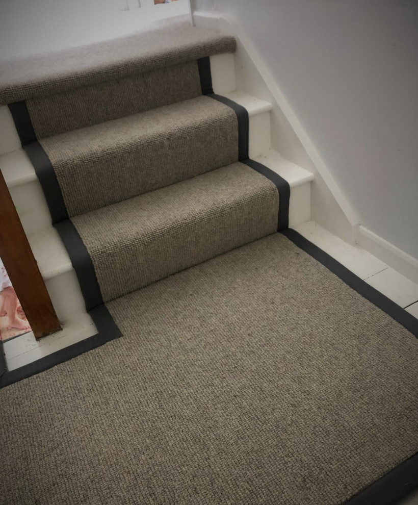 Inspiration for a modern carpeted wood railing staircase in Hertfordshire with carpeted risers.