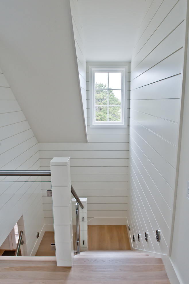 Diseño de escalera en U marinera con escalones de madera y contrahuellas de madera pintada