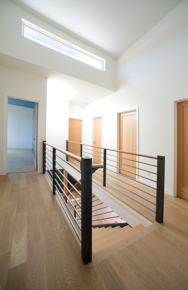 Aménagement d'un escalier moderne en L de taille moyenne avec des marches en bois et des contremarches en métal.