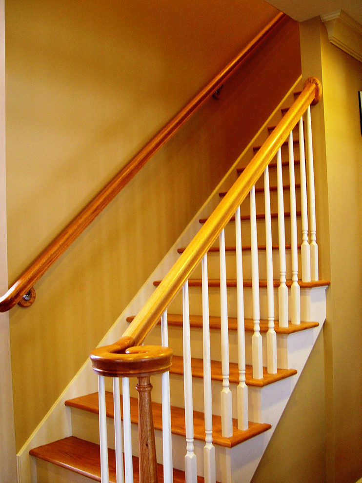 Modelo de escalera recta tradicional pequeña con escalones de madera, contrahuellas de madera pintada y barandilla de madera