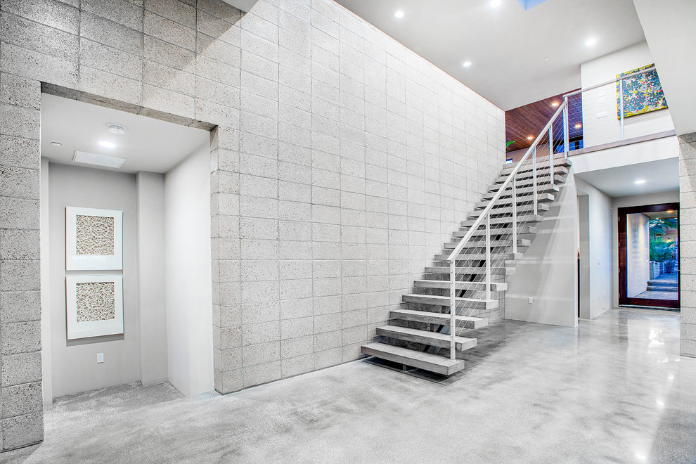 На фото: большая прямая лестница в стиле модернизм с бетонными ступенями без подступенок