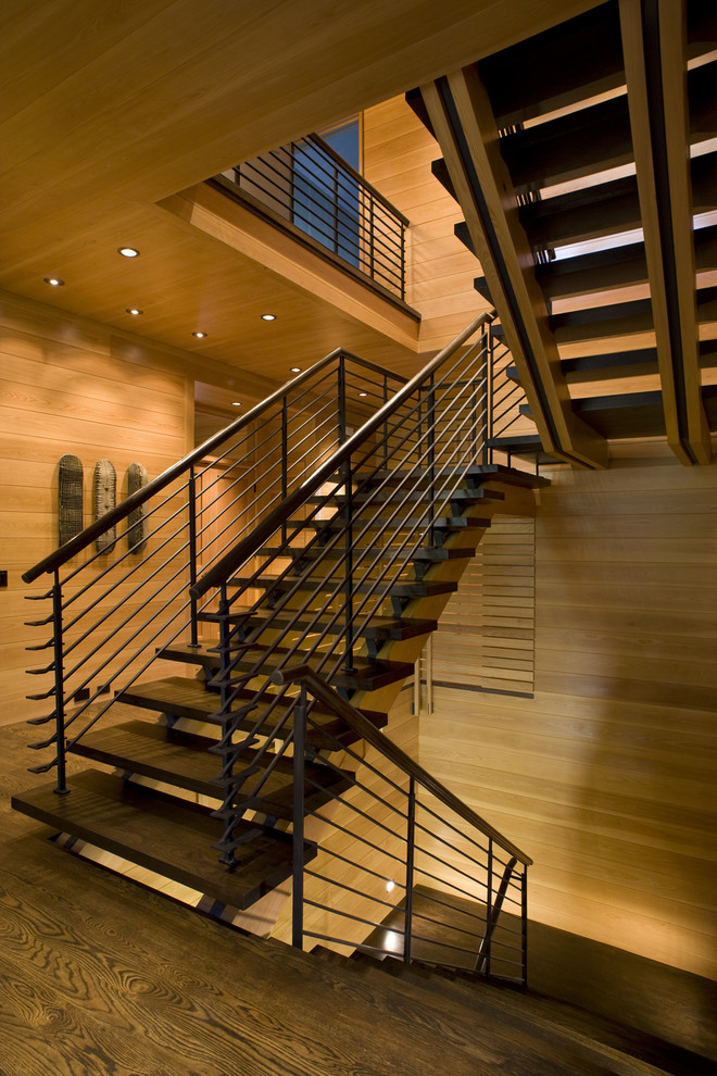 На фото: п-образная лестница в стиле неоклассика (современная классика) с деревянными ступенями и металлическими перилами без подступенок