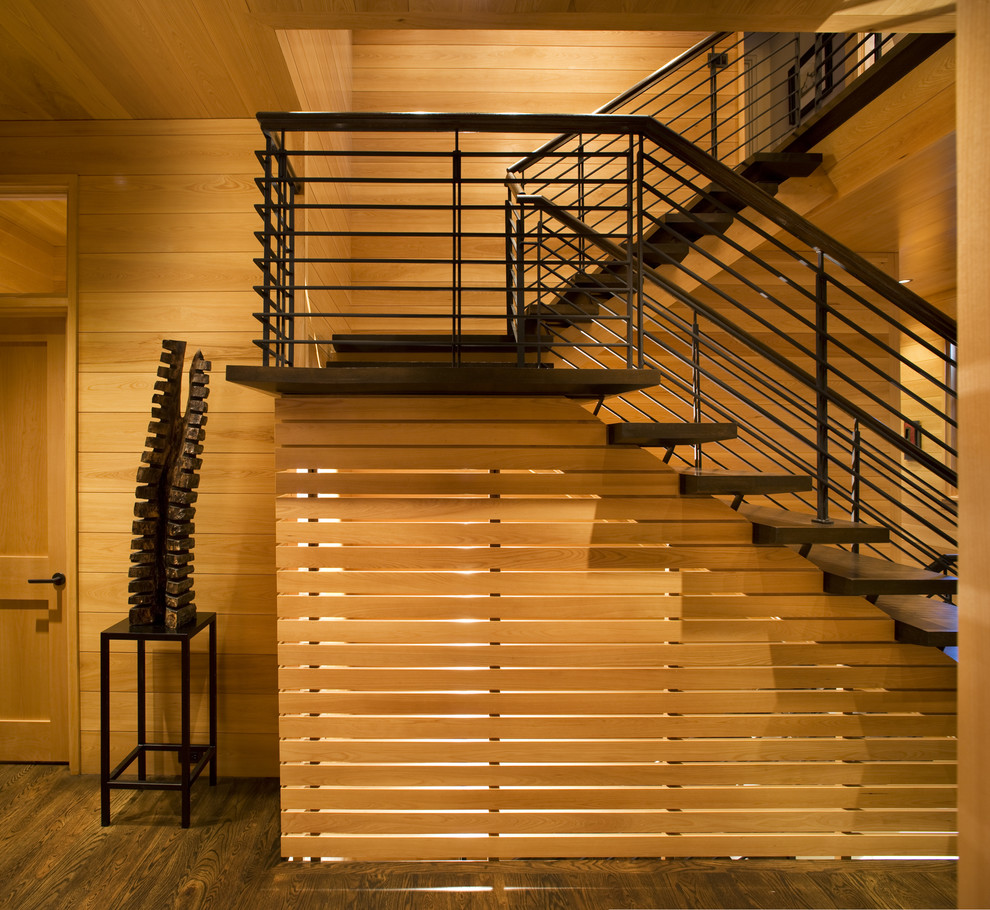 Ejemplo de escalera en U clásica renovada sin contrahuella con escalones de madera y barandilla de metal