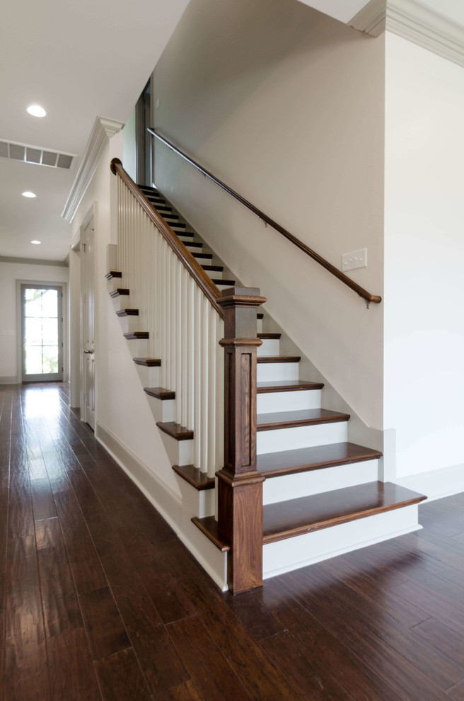 На фото: угловая лестница среднего размера в классическом стиле с деревянными ступенями и крашенными деревянными подступенками