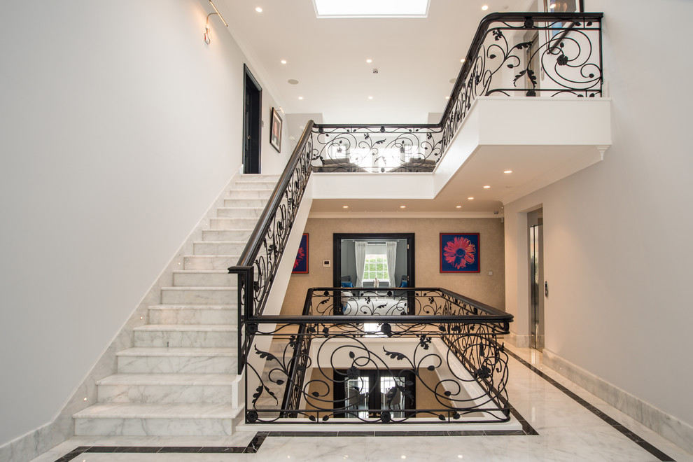 Diseño de escalera recta contemporánea grande con escalones de mármol, contrahuellas de mármol y barandilla de metal