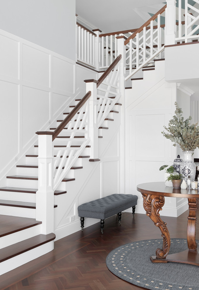 Свежая идея для дизайна: огромная п-образная лестница в морском стиле с деревянными ступенями, крашенными деревянными подступенками, деревянными перилами и панелями на стенах - отличное фото интерьера
