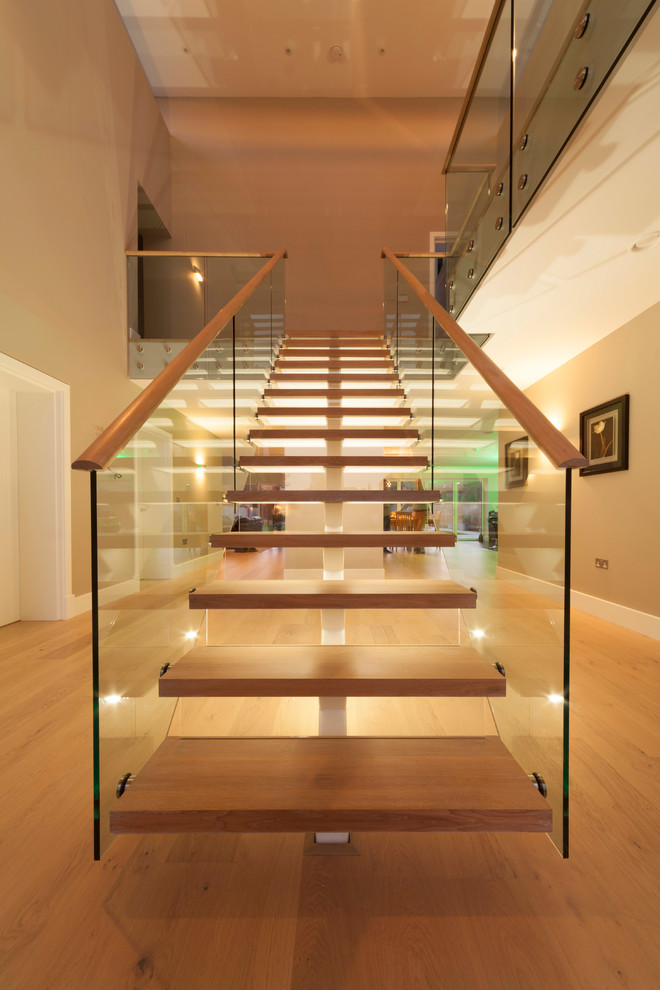 Design ideas for a large contemporary wood straight staircase in Cambridgeshire with open risers.
