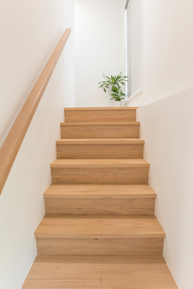 Пример оригинального дизайна: большая угловая деревянная лестница в современном стиле с деревянными ступенями и деревянными перилами