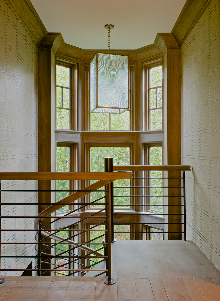 На фото: изогнутая лестница среднего размера в стиле неоклассика (современная классика) с деревянными ступенями с