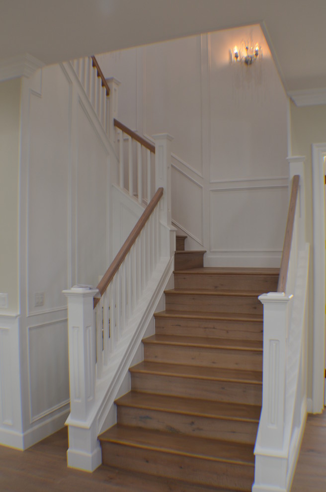 Mid-sized elegant wooden curved wood railing staircase photo in Los Angeles with wooden risers