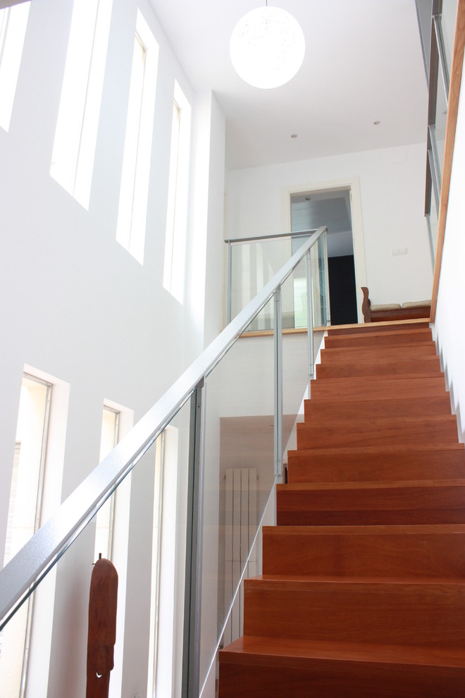 На фото: большая прямая деревянная лестница в современном стиле с деревянными ступенями и металлическими перилами с