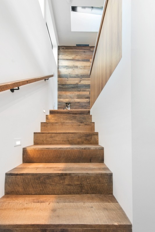На фото: угловая деревянная лестница среднего размера в стиле модернизм с деревянными ступенями