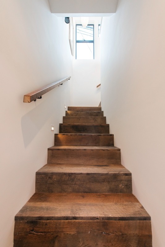 На фото: угловая деревянная лестница среднего размера в стиле модернизм с деревянными ступенями