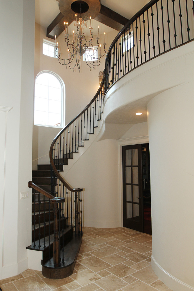 Cette image montre un grand escalier hélicoïdal traditionnel avec des marches en bois et des contremarches en bois.