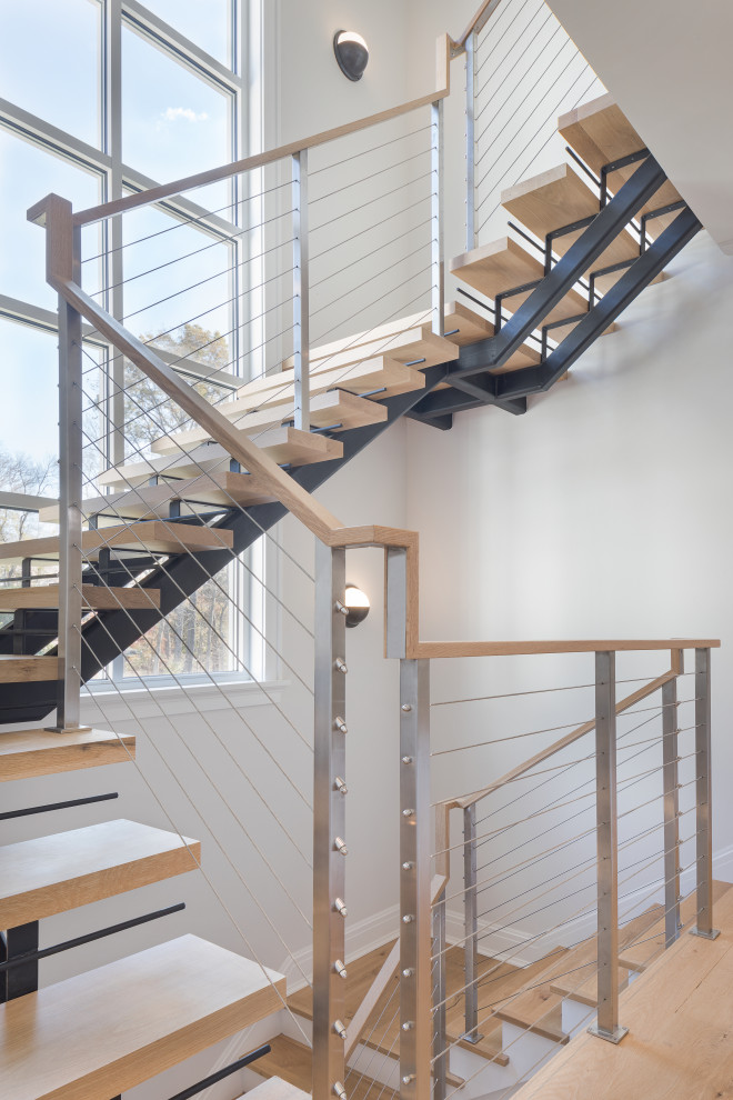Ejemplo de escalera suspendida campestre grande sin contrahuella con escalones de madera y barandilla de cable