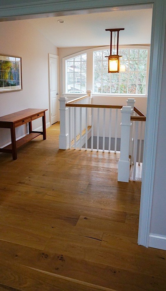 Ejemplo de escalera en U clásica de tamaño medio con escalones de madera, contrahuellas de madera y barandilla de madera