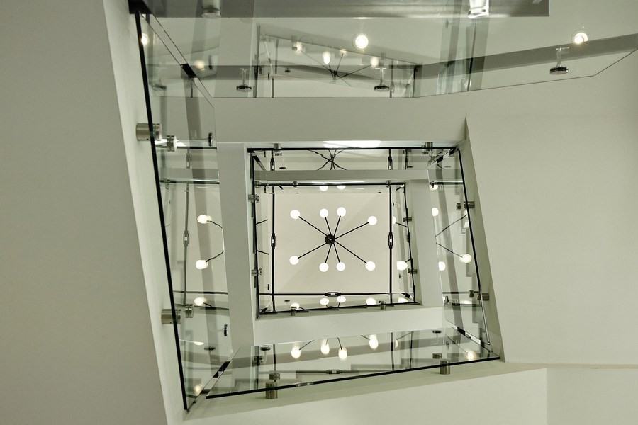 На фото: п-образная бетонная лестница среднего размера в стиле неоклассика (современная классика) с бетонными ступенями и стеклянными перилами