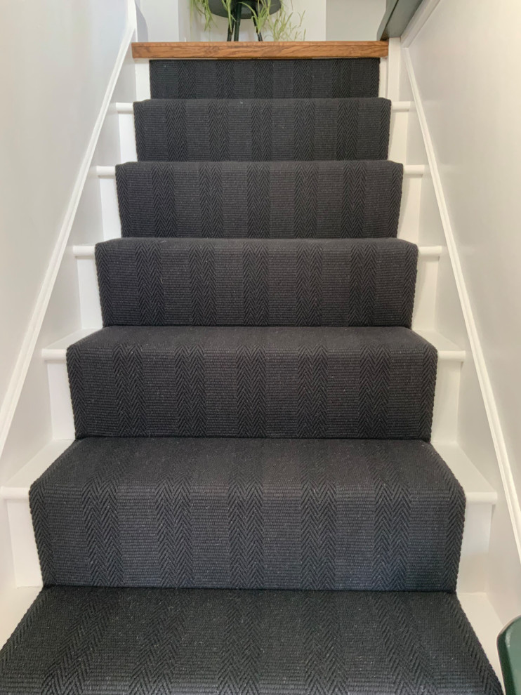 Example of a trendy carpeted staircase design in Hertfordshire with carpeted risers