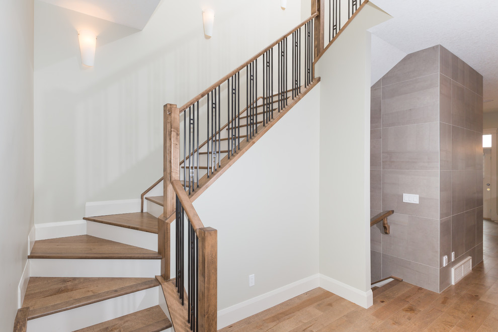 Ejemplo de escalera en L contemporánea de tamaño medio con escalones de madera, contrahuellas de madera pintada y barandilla de metal