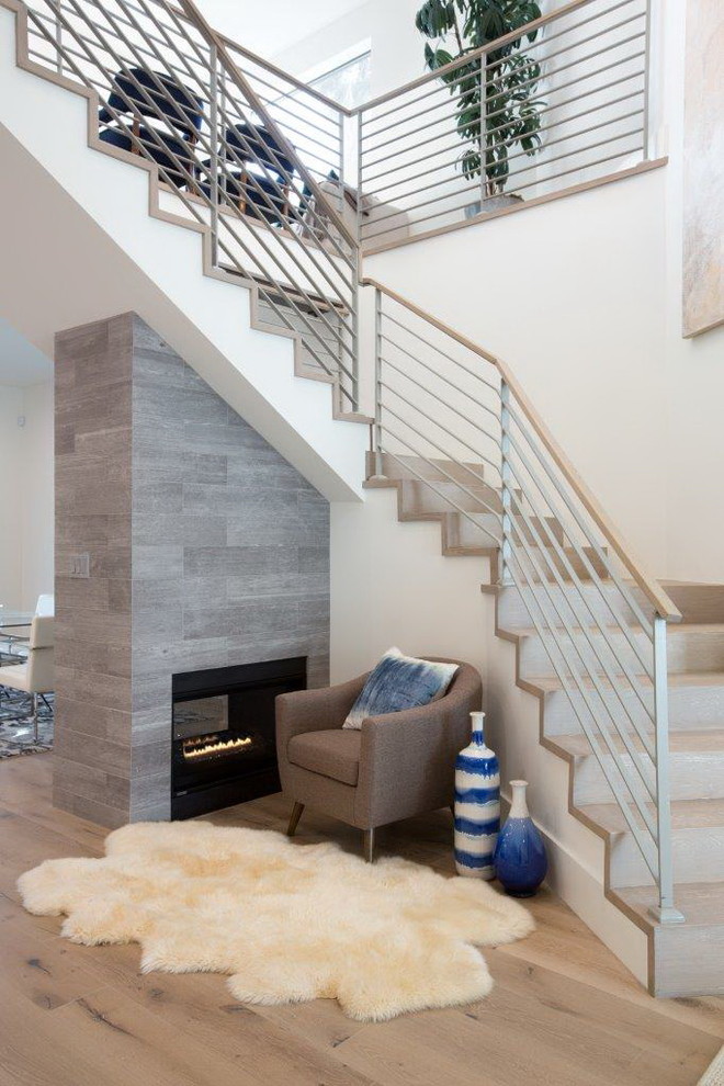 На фото: угловая лестница среднего размера в стиле модернизм с ступенями из плитки, подступенками из плитки и металлическими перилами