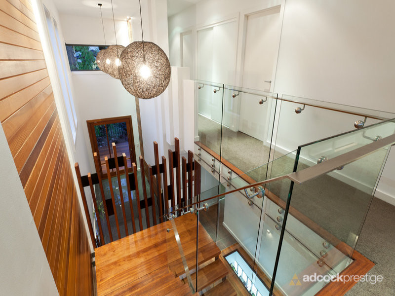 Стильный дизайн: п-образная металлическая лестница среднего размера в современном стиле с деревянными ступенями и металлическими перилами - последний тренд