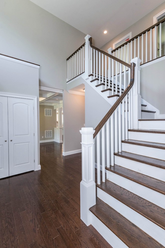 Photo of a medium sized classic wood curved wood railing staircase in New York with painted wood risers.