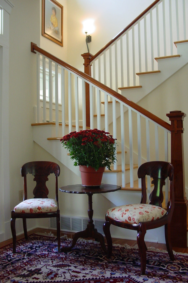 Ejemplo de escalera en U tradicional de tamaño medio con escalones de madera, contrahuellas de madera pintada y barandilla de madera