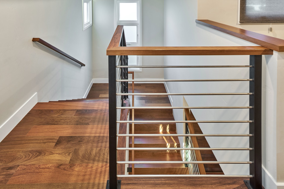 Ejemplo de escalera en U tradicional renovada de tamaño medio con escalones de madera, contrahuellas de madera y barandilla de varios materiales