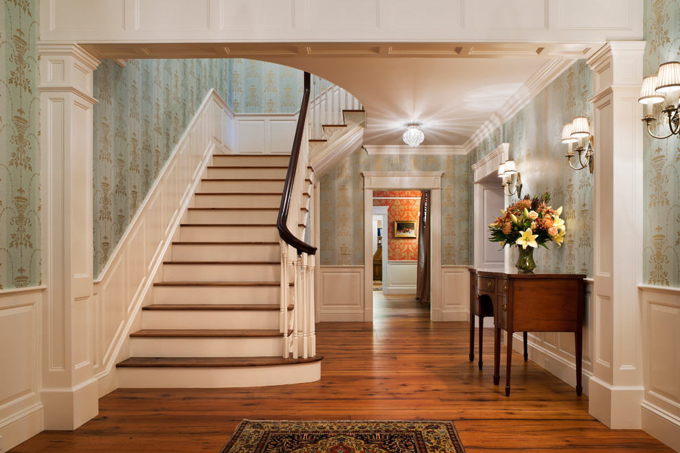 Large classic wood l-shaped wood railing staircase in New York with painted wood risers.