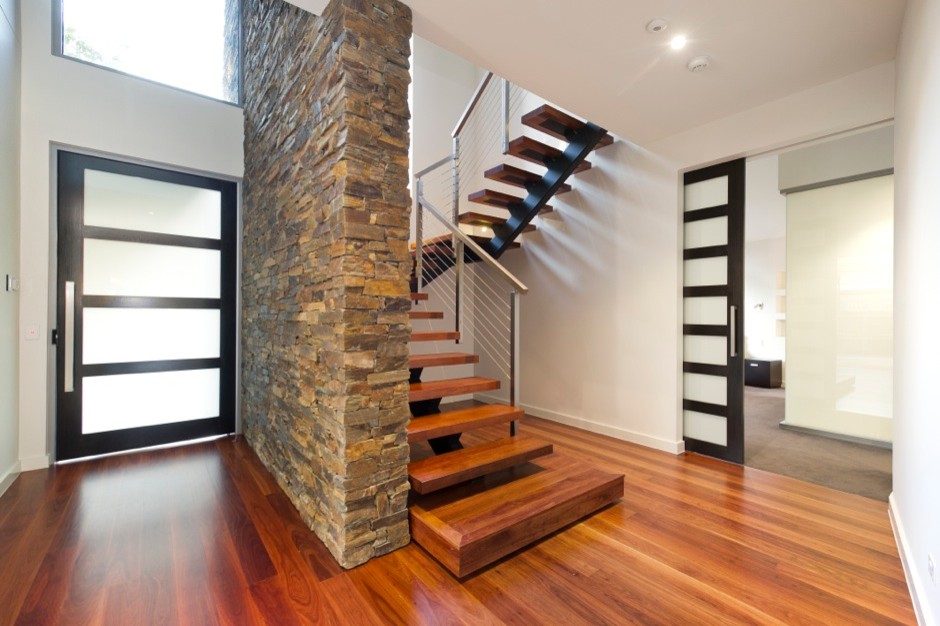 Diseño de escalera en U actual grande sin contrahuella con escalones de madera