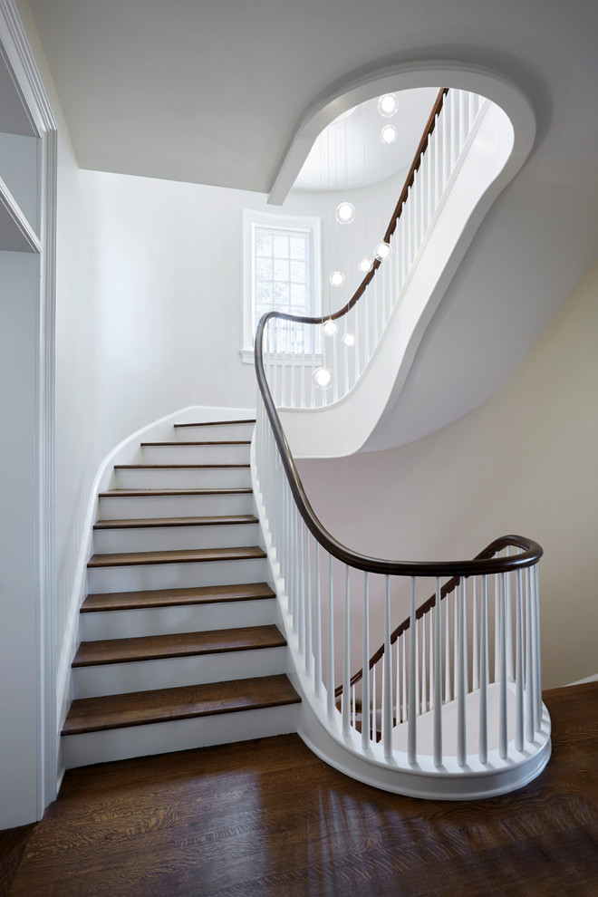 Cette image montre un très grand escalier courbe design avec éclairage.