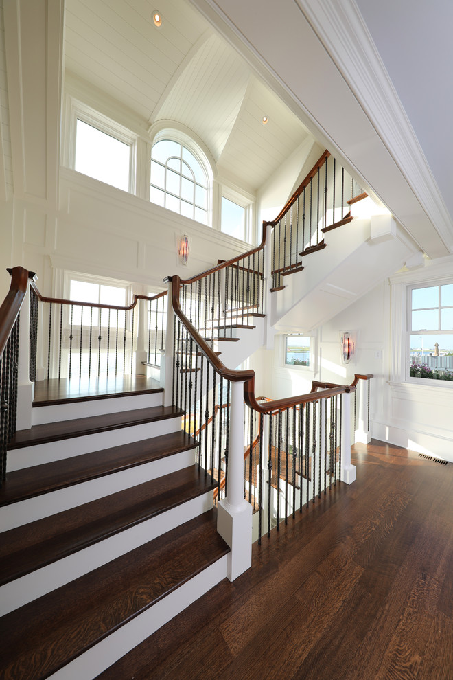 Foto de escalera en U costera grande con escalones de madera, contrahuellas de madera pintada y barandilla de madera