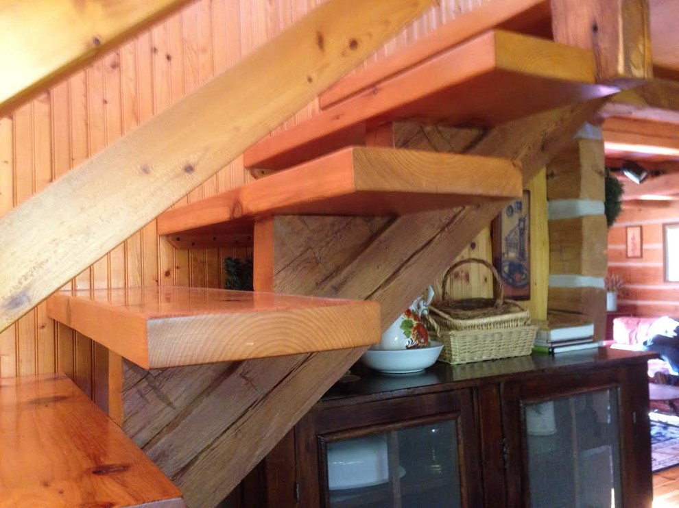 Imagen de escalera recta rústica de tamaño medio sin contrahuella con escalones de madera y barandilla de madera